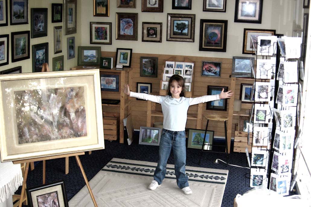 Jordan A. Cook in her gallery at age 7, surrounded by her paintings